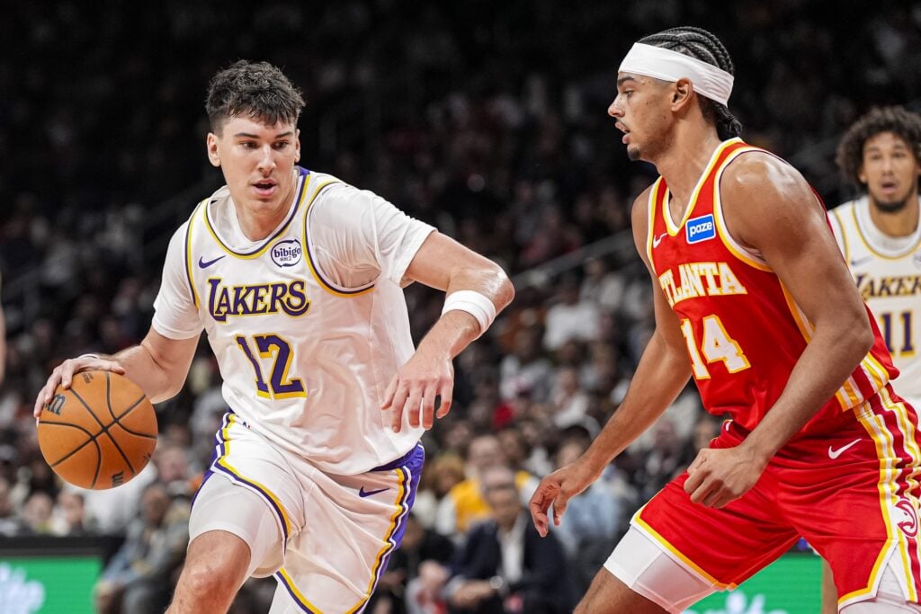 Los Angeles Lakers forward Jake LaRavia (12) dribbles against Atlanta Hawks forward Asa Newell (14) during the first half at State Farm Arena.