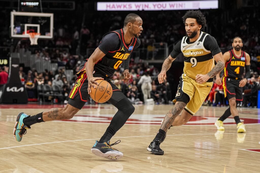 Feb 24, 2026; Atlanta, Georgia, USA; Atlanta Hawks forward Jonathan Kuminga (0) dribbles past Washington Wizards forward Justin Champagnie (9) during the second half at State Farm Arena. Mandatory Credit: Dale Zanine-Imagn Images